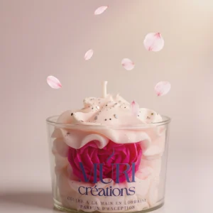 Bougie parfumée à la fleur de cerisier de la marque artisanale Muri Créations, coulée à la main en Lorraine. Bougie gourmande en verre avec cire effet chantilly pailletée, ornée d'une fleur rose fuchsia et entourée de pétales de cerisier flottants.