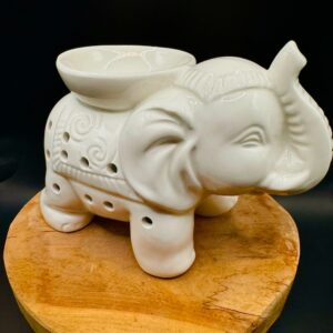 Brûleur d’arômes en céramique blanche en forme d’éléphant, posé sur un support bois