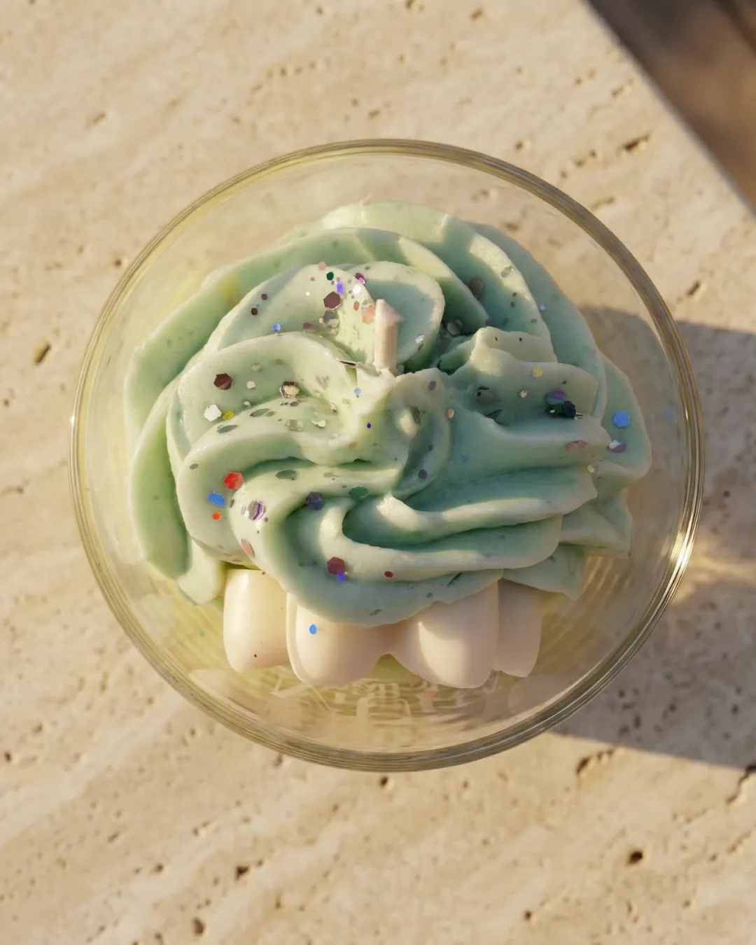 Bougie 150ml - JASMIN 2 Vue de dessus d'une bougie artisanale Muri Créations au parfum floral de jasmin, disposant d'une cire fouettée verte pailletée style chantilly dans un verre, issue de la collection printemps été 2026.