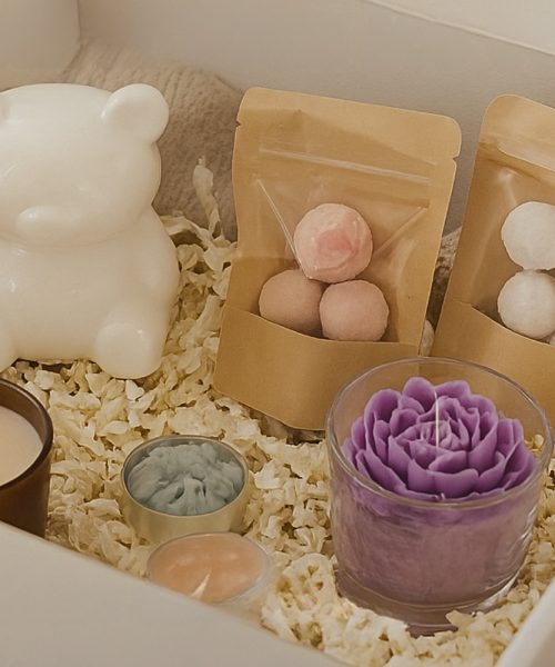 Coffret abonnement MuriBox ouvert contenant des bougies artisanales pastel sur table en bois brut
